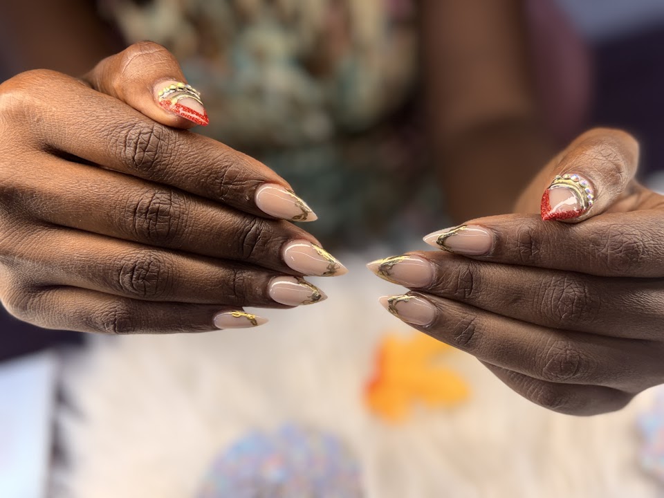 Nude almond nails with gold accents and red statement tips