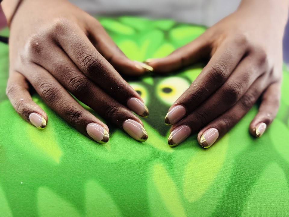 Nude almond nails with a gleaming gold French tip